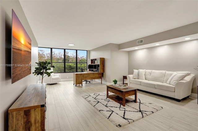 living room with light wood-type flooring, baseboards, visible vents, and recessed lighting