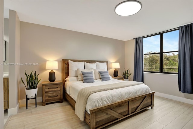 bedroom with light wood finished floors and baseboards