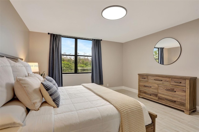 bedroom with light wood-style floors and baseboards