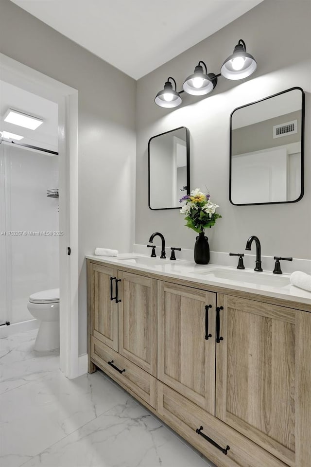 bathroom with toilet, marble finish floor, visible vents, and a sink