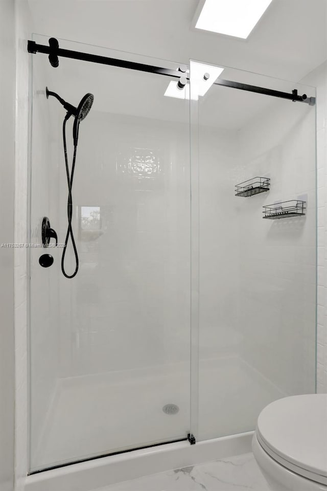 full bathroom with a stall shower, marble finish floor, and toilet