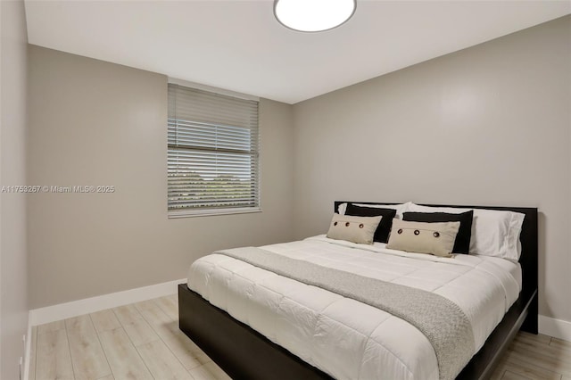 bedroom with light wood-type flooring and baseboards