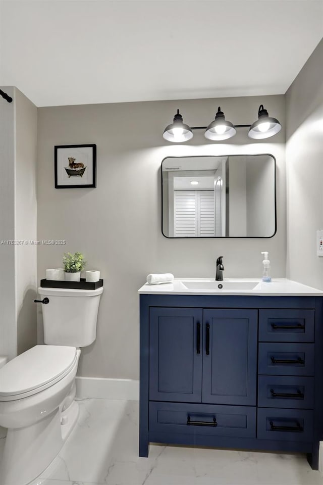 bathroom featuring marble finish floor, vanity, toilet, and baseboards