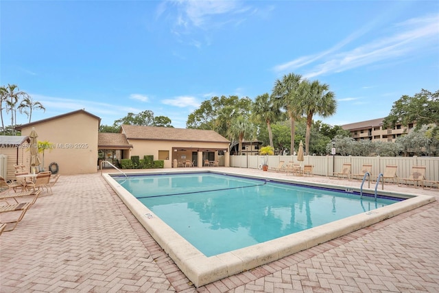 community pool featuring fence and a patio