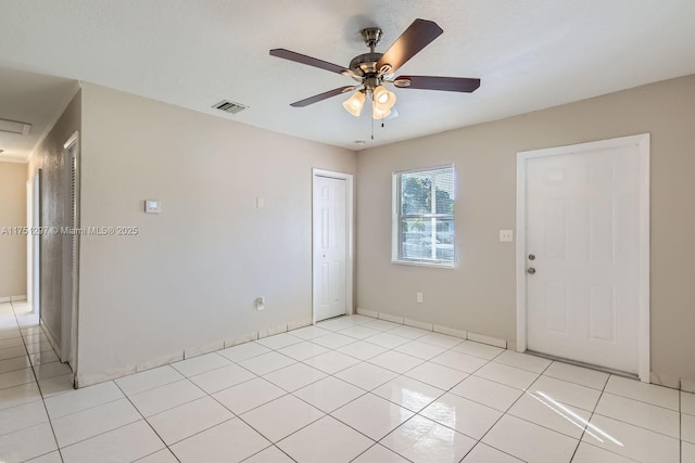 unfurnished room featuring light tile patterned floors, visible vents, and a ceiling fan