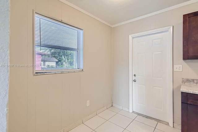 spare room featuring light tile patterned floors and ornamental molding