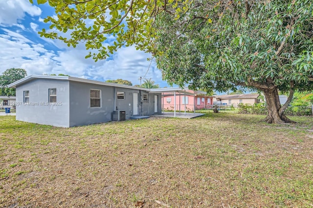 back of house with a lawn, a patio, fence, central air condition unit, and stucco siding