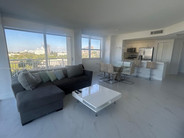 living room with marble finish floor, visible vents, and a city view