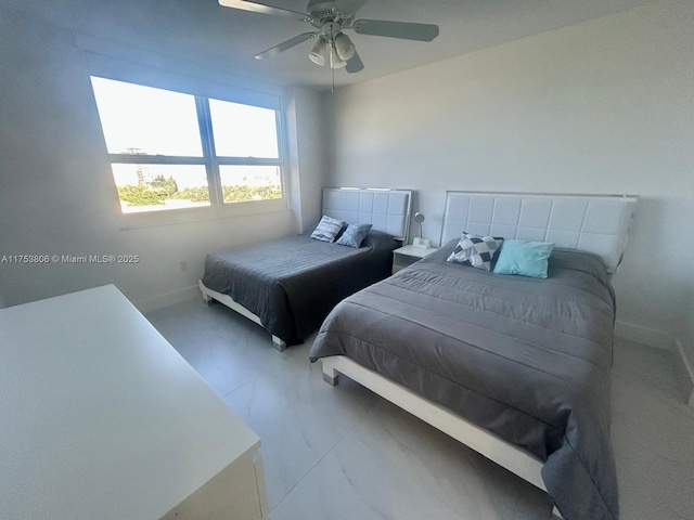 bedroom with ceiling fan, marble finish floor, and baseboards