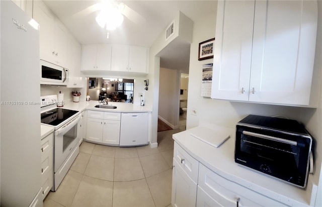 kitchen featuring light countertops, light tile patterned floors, white appliances, white cabinetry, and a sink