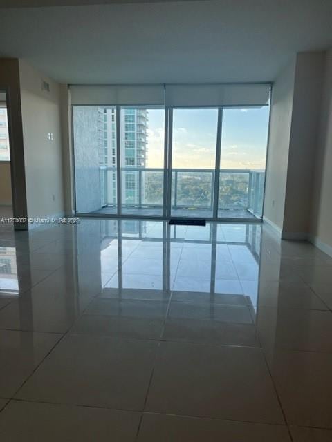 unfurnished room with visible vents, baseboards, and tile patterned floors