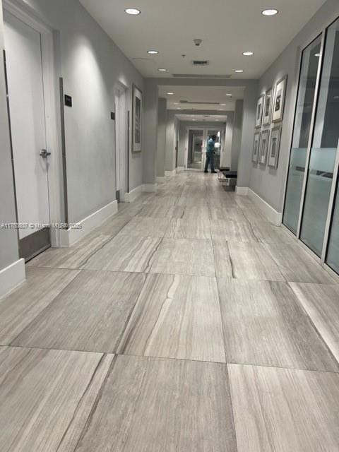 hallway with baseboards and recessed lighting