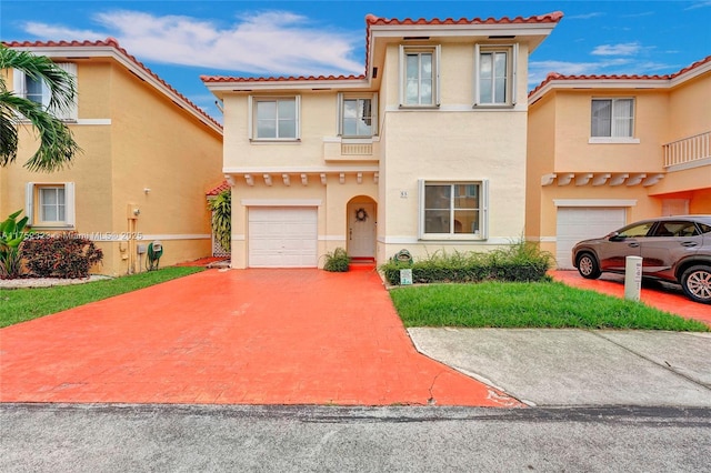 mediterranean / spanish home featuring a garage, decorative driveway, and stucco siding