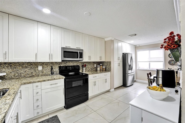 kitchen featuring stainless steel appliances, tasteful backsplash, visible vents, white cabinets, and light stone countertops