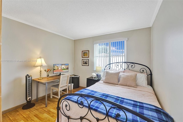 bedroom featuring baseboards, crown molding, light wood-style flooring, and a textured ceiling