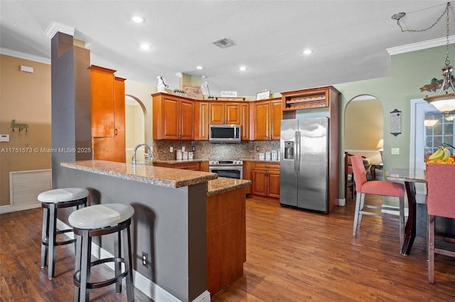 16358 S Mariposa Cir S, Pembroke Pines, FL 33331 - kitchen featuring brown cabinetry, crown molding, appliances with stainless steel finishes, and visible vents