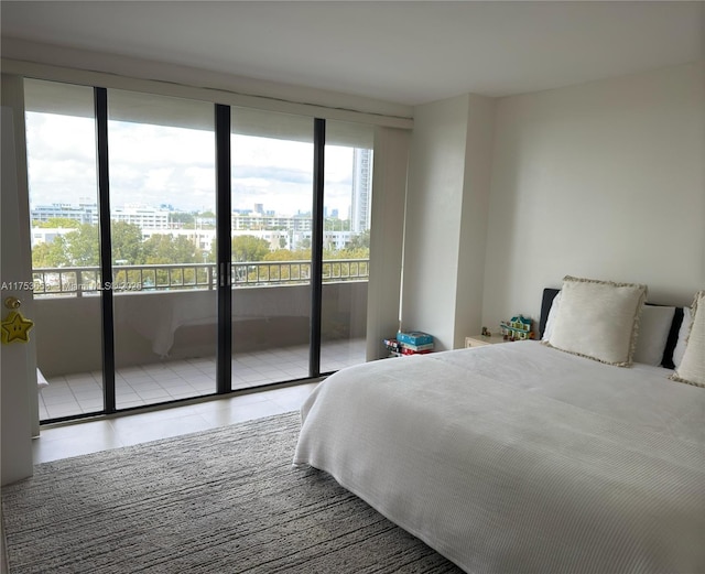 bedroom featuring access to exterior, tile patterned flooring, and a city view