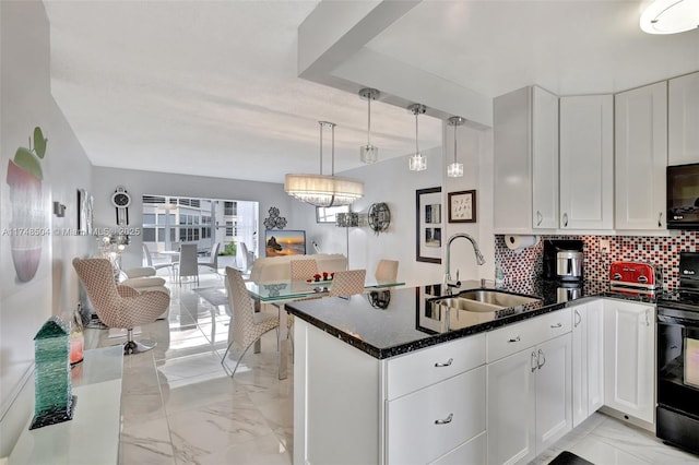 kitchen featuring marble finish floor, decorative backsplash, white cabinets, a sink, and a peninsula