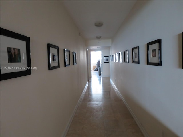 hallway with tile patterned flooring and baseboards