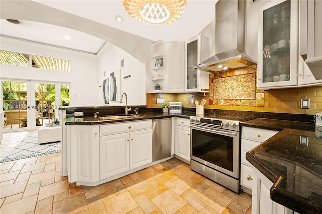 1109 NE 3rd St, Fort Lauderdale, FL 33301 - kitchen featuring white cabinetry, stainless steel appliances, a sink, wall chimney range hood, and a peninsula