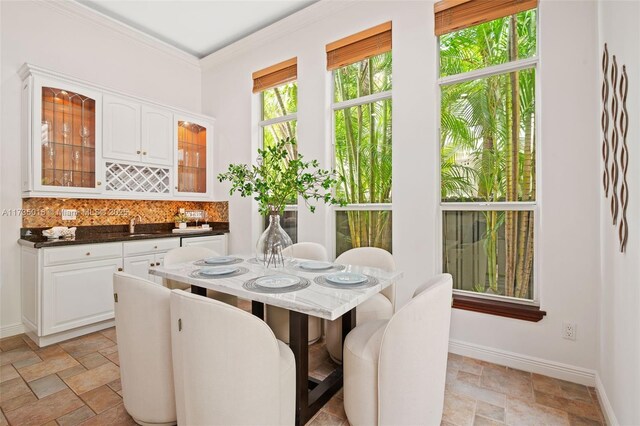 1109 NE 3rd St, Fort Lauderdale, FL 33301 - dining area featuring baseboards, crown molding, bar, and stone tile flooring