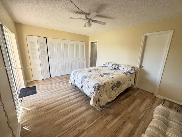 bedroom with light wood-type flooring, a closet, a ceiling fan, and a textured ceiling