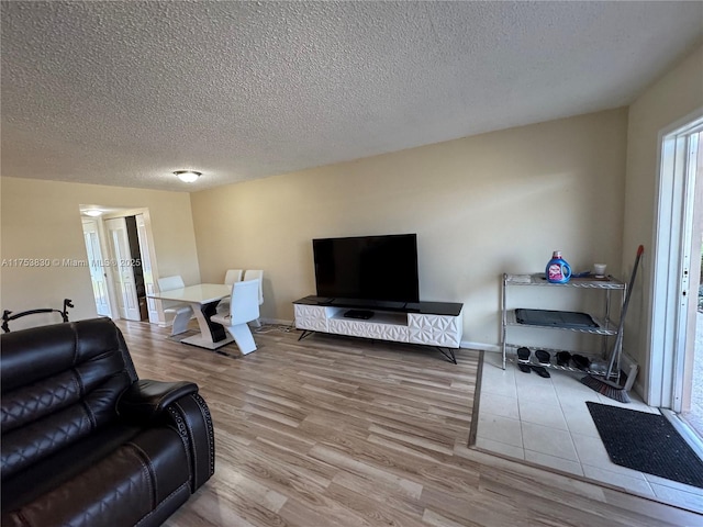 living room featuring a textured ceiling, wood finished floors, and baseboards