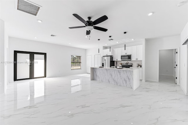 kitchen featuring visible vents, white cabinets, marble finish floor, appliances with stainless steel finishes, and pendant lighting