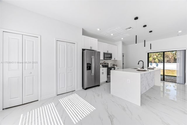 kitchen featuring marble finish floor, visible vents, appliances with stainless steel finishes, white cabinetry, and a sink