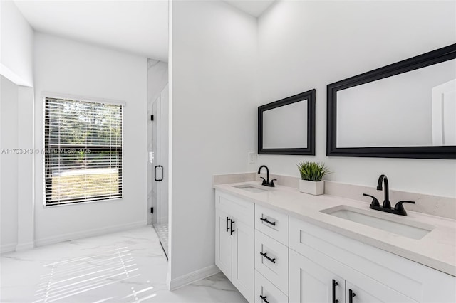 full bathroom with a stall shower, marble finish floor, a sink, and baseboards