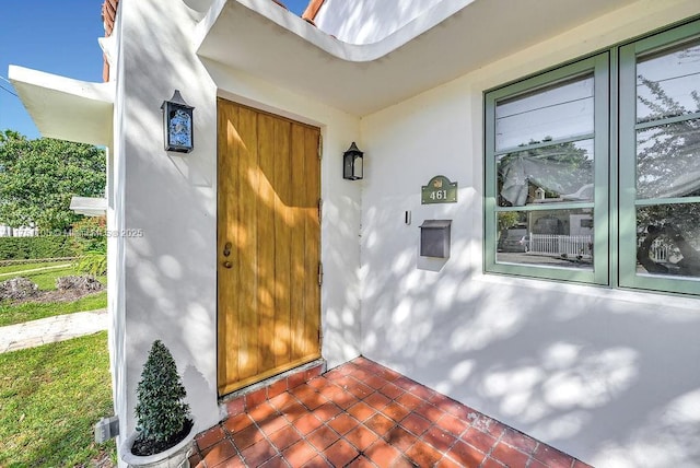 view of exterior entry featuring stucco siding