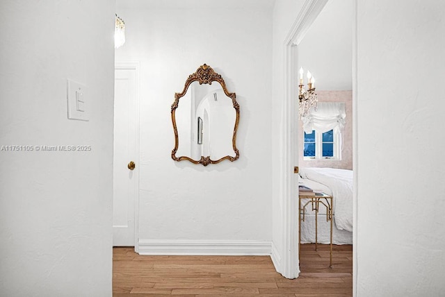 hall featuring wood finished floors and baseboards