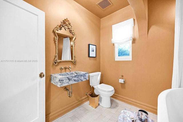 bathroom featuring baseboards, visible vents, and toilet