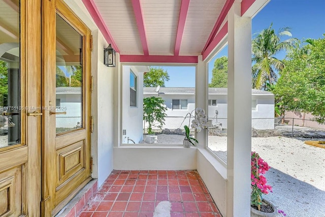 unfurnished sunroom with beamed ceiling