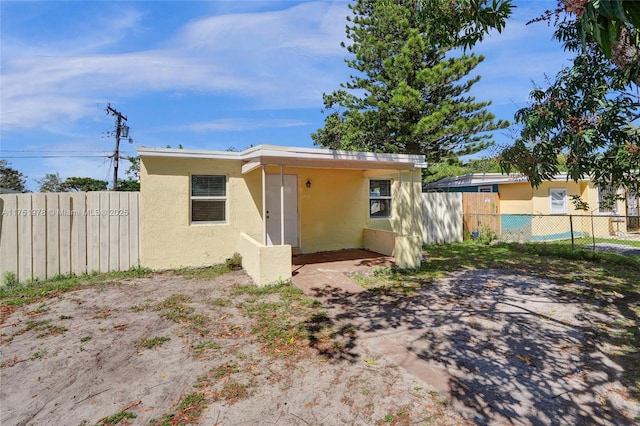 view of front of house featuring fence and stucco siding