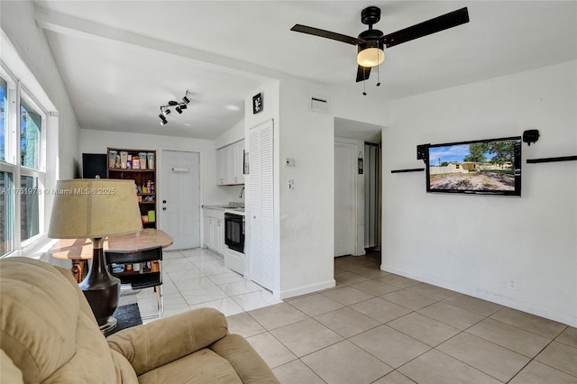 living area with baseboards, visible vents, and a ceiling fan