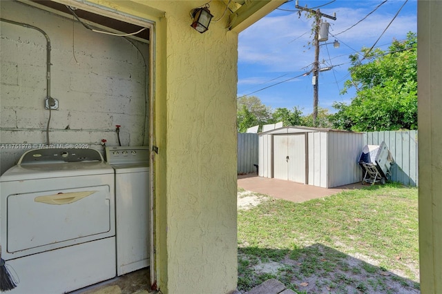 laundry area with laundry area, a textured wall, and washer and clothes dryer