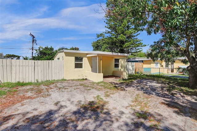 view of front of property featuring fence and stucco siding