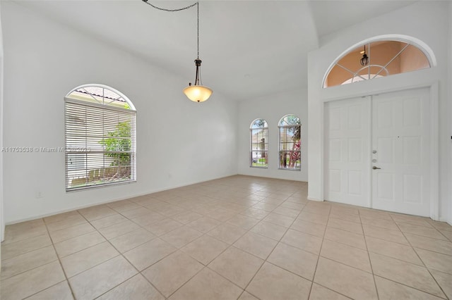 entrance foyer featuring light tile patterned floors and vaulted ceiling