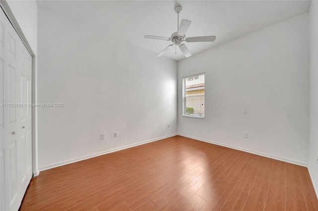 unfurnished bedroom featuring a closet, ceiling fan, baseboards, and wood finished floors