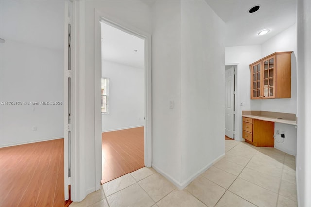 hallway featuring light tile patterned floors and baseboards