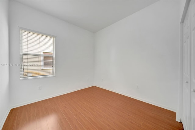 empty room with baseboards and wood finished floors