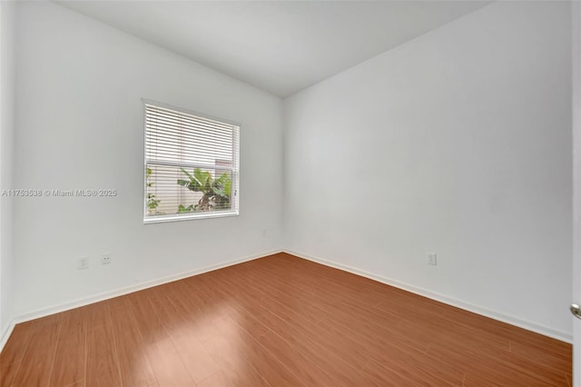 empty room with baseboards and wood finished floors