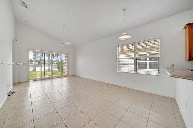 spare room with lofted ceiling, visible vents, a ceiling fan, light tile patterned flooring, and baseboards