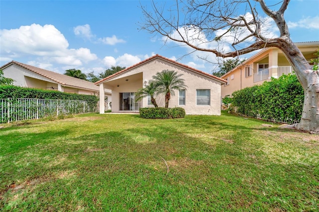 back of house featuring stucco siding, a yard, and fence