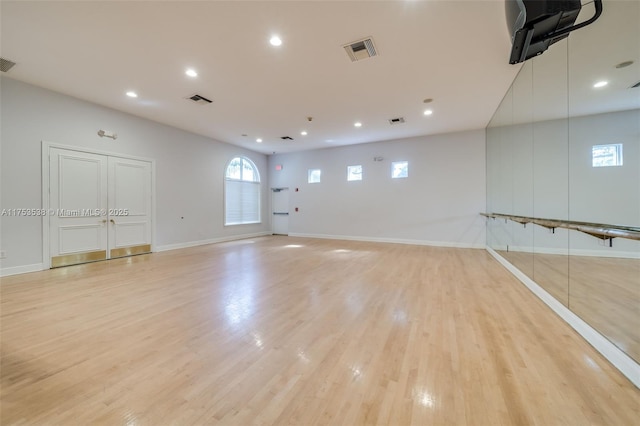 empty room with light wood-type flooring and visible vents