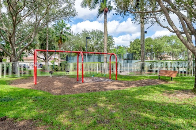 community jungle gym featuring fence and a yard