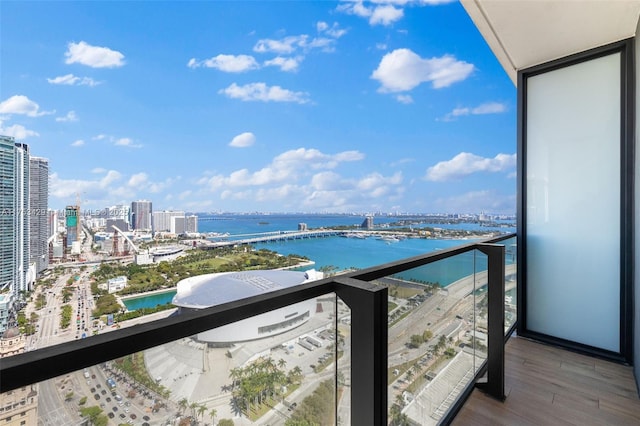 balcony with a water view and a view of city