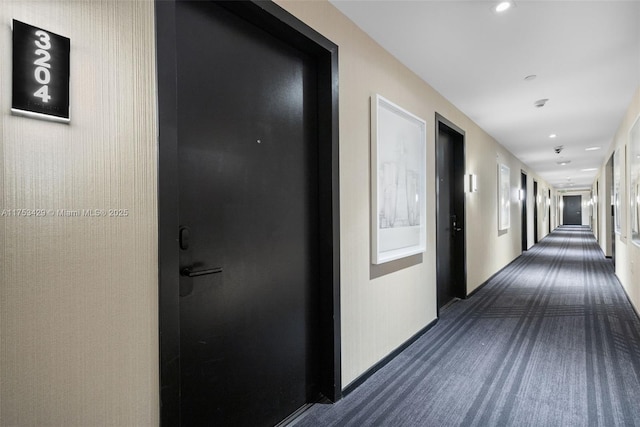 corridor with recessed lighting, dark carpet, and baseboards