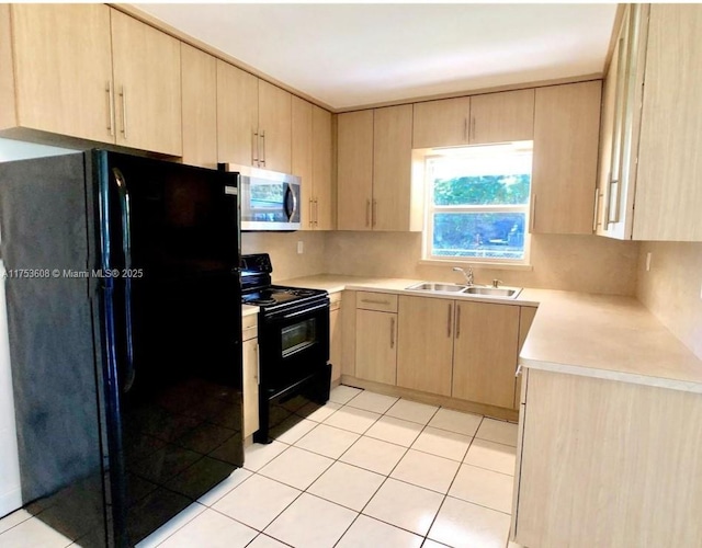 kitchen featuring black appliances, light brown cabinetry, a sink, and light countertops